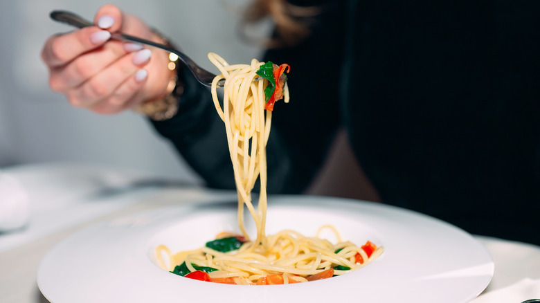 woman eating bowl of pasta