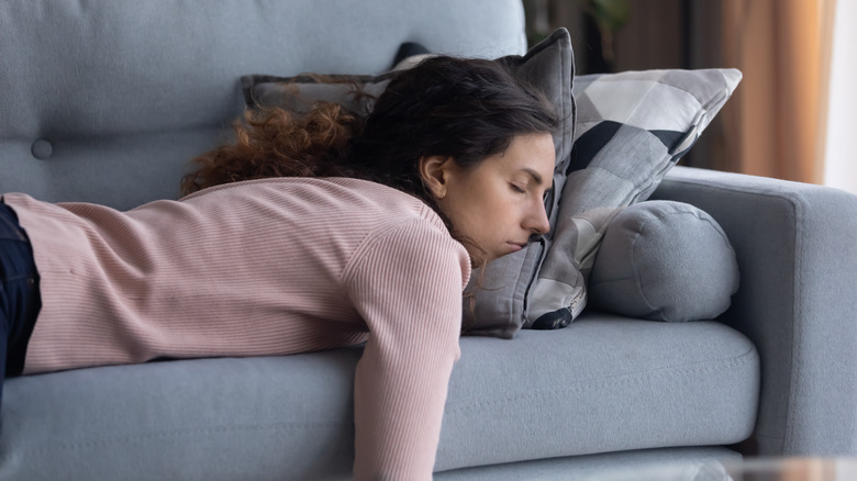 A woman naps on the couch