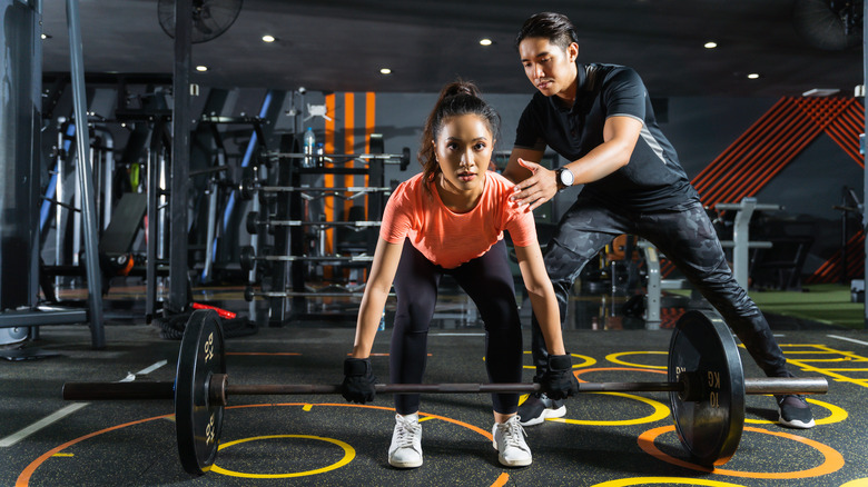 A trainer helping a client with a deadlift