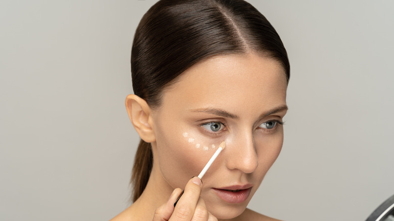 A woman applying face primer