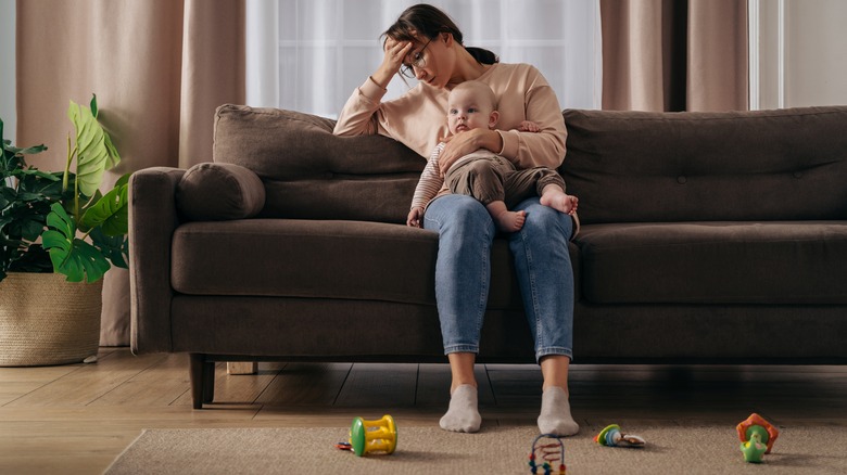 stressed woman holding baby in lap