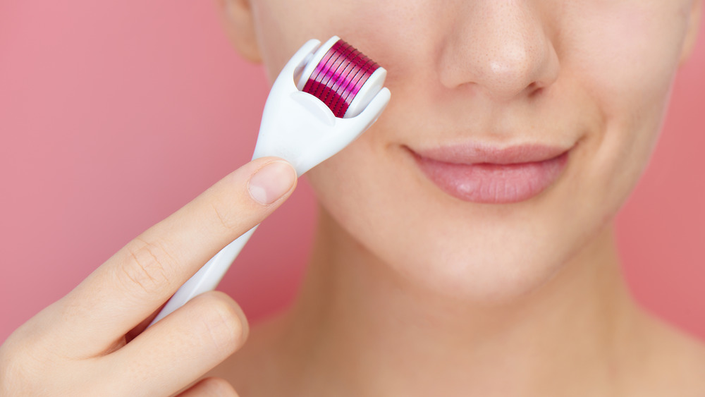 Woman giving herself a microneedling treatment 