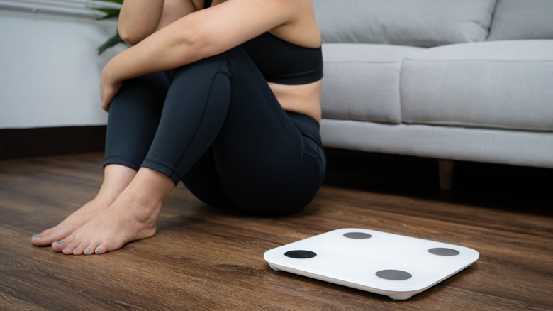 woman sitting by a scale