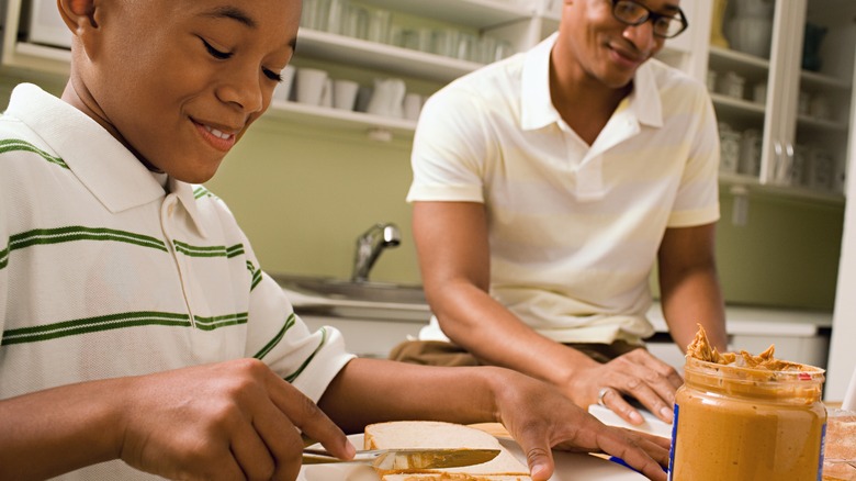father and son making peanut butter sandwiches