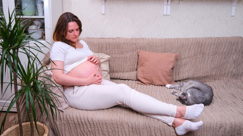 Pregnant woman scratching her belly