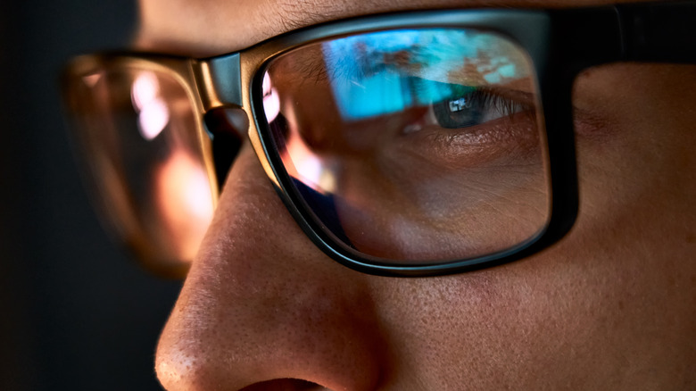 Close-up of man looking at screen at night