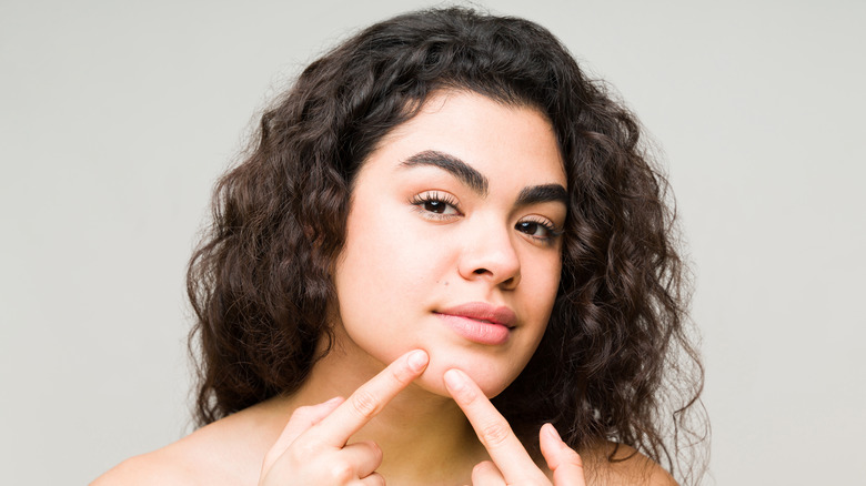 woman squeezing skin on chin