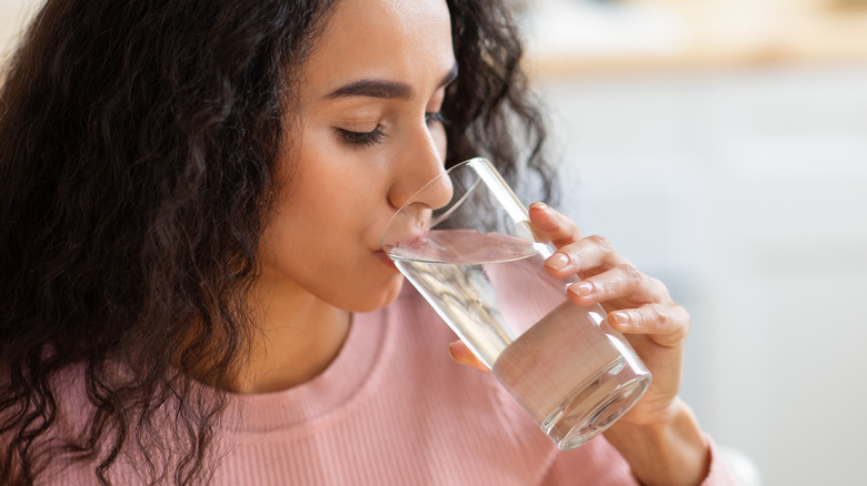 woman drinking water from glass