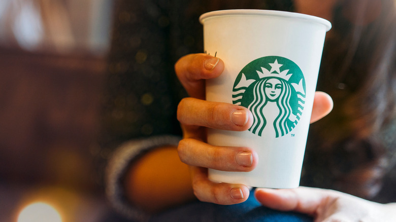 woman drinking tall Starbucks latte