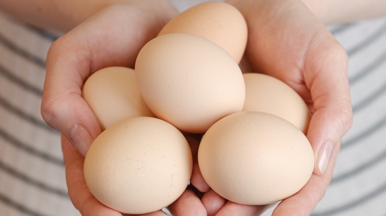 woman holding large white eggs