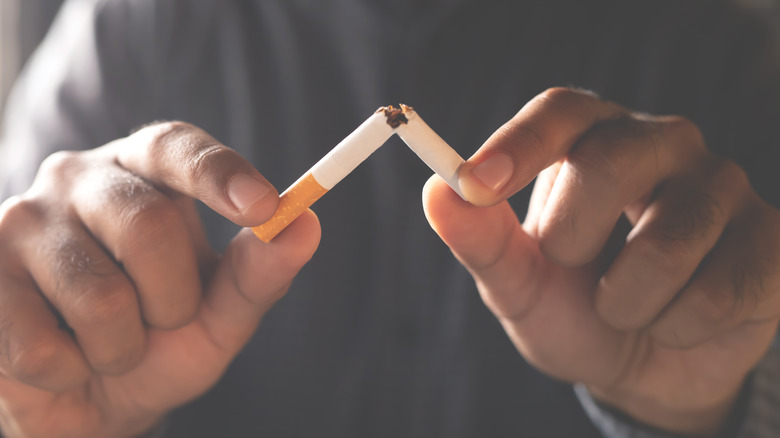 Close-up of hands breaking a cigarette 