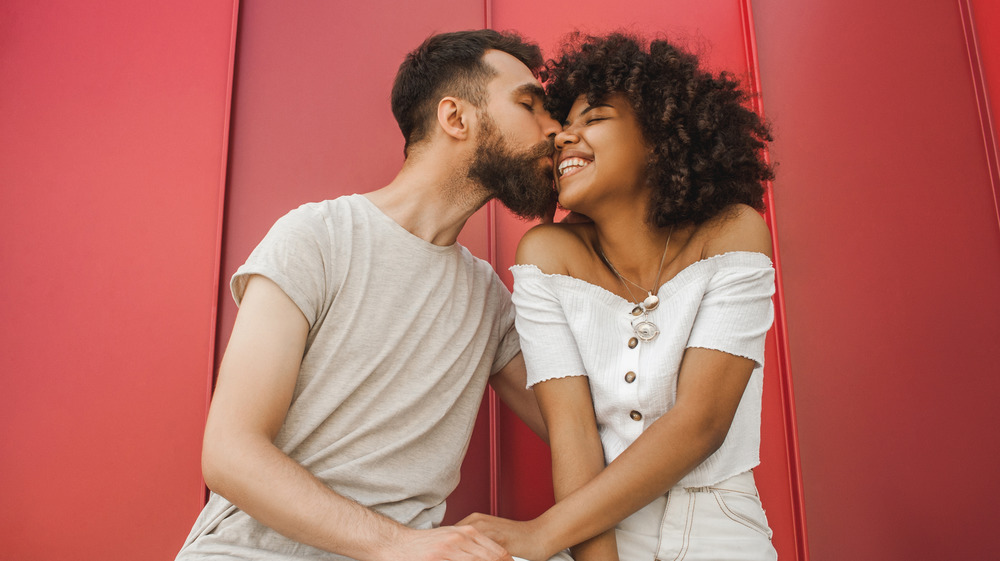 Woman kissing bearded man