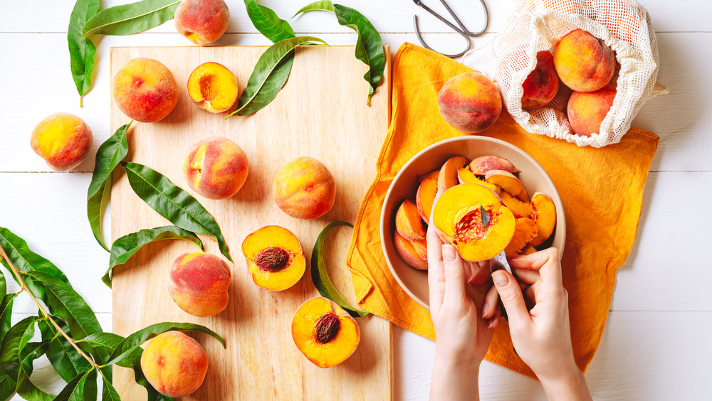 Peaches being cut and prepared in bowl