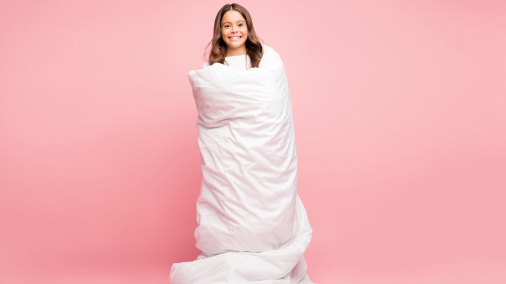 Smiling girl wrapped in blanket