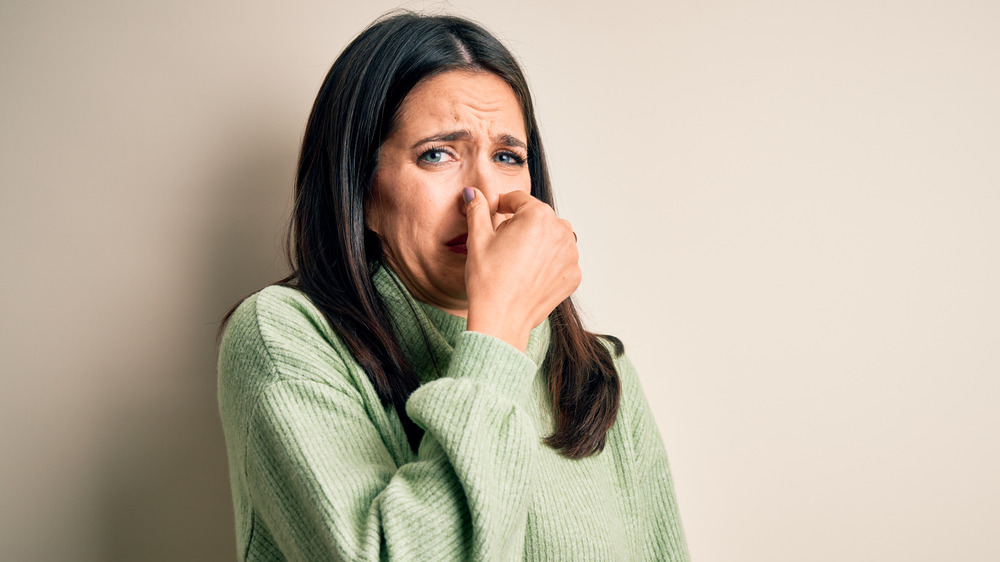 Woman holding nose 