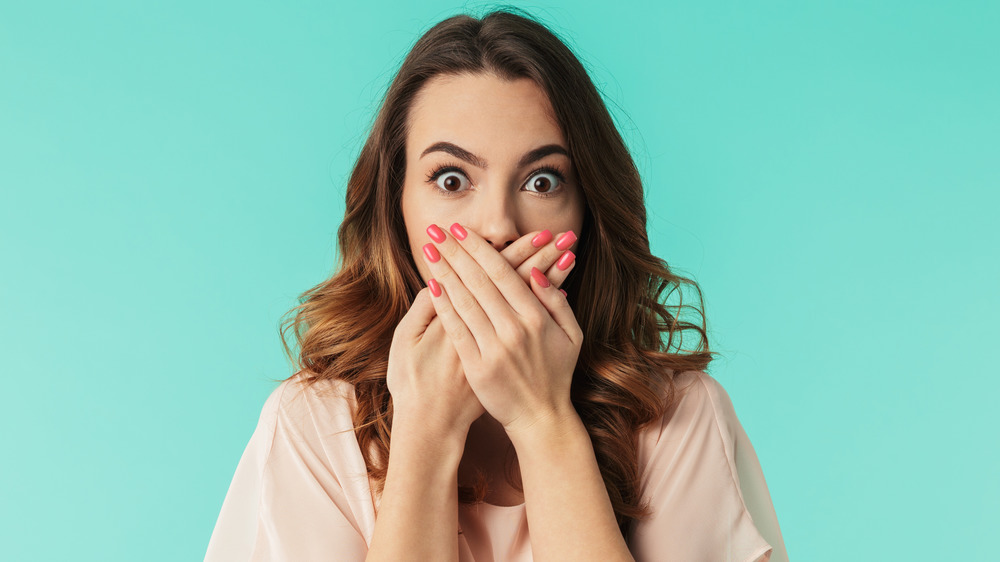 Woman covering mouth 