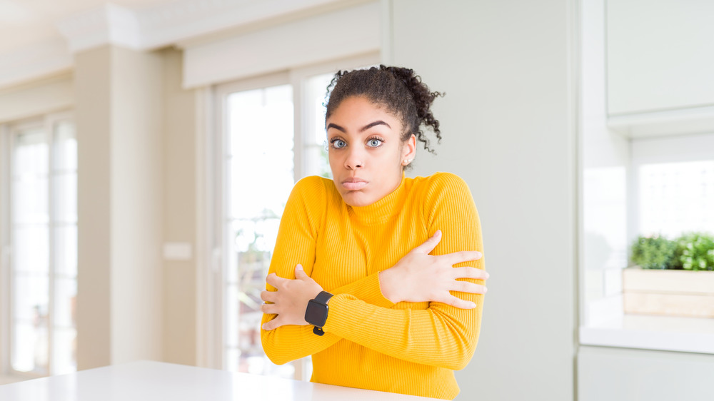 Woman in yellow shirt shivering