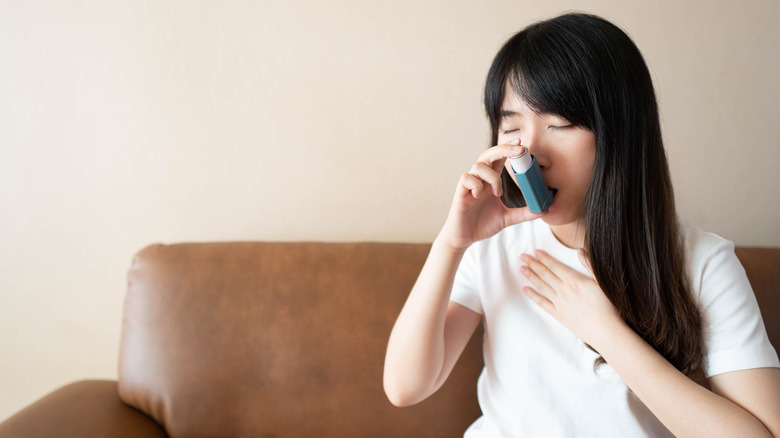 A woman uses an inhaler