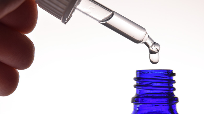 hand holding dropper of liquid