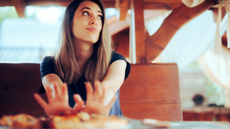 woman pushing away her lunch plate