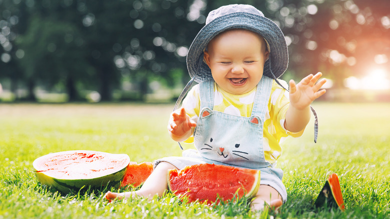 Smiling child eating watermelon outside