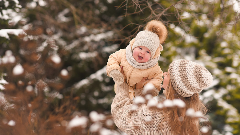 mom playing with baby in snow