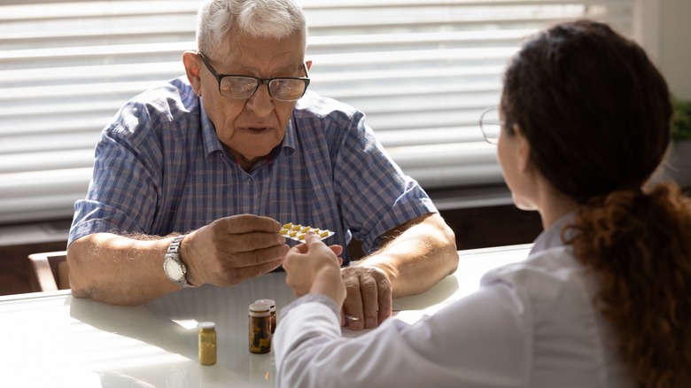 man getting handed some pills 