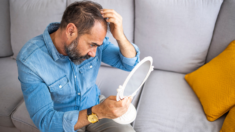 man sitting down holding head