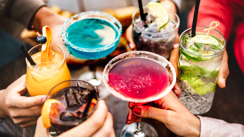 close up of several cocktails toasting