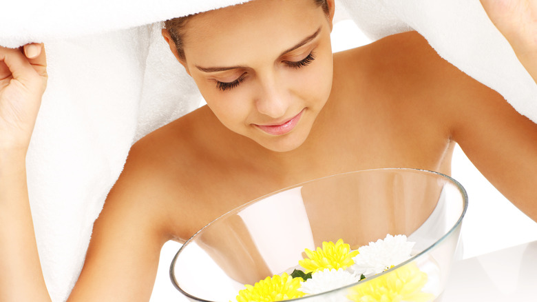 woman steaming face over bowl