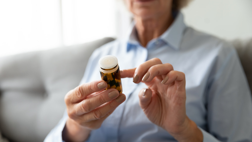 woman reading pill bottle information