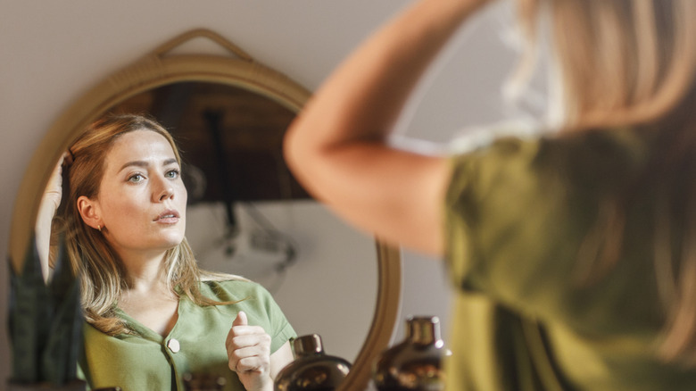 woman looking at herself in mirror