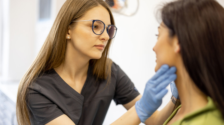 dermatologist working with patient in office setting