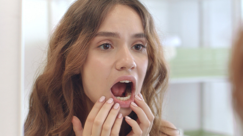 Woman checking her gums in mirror