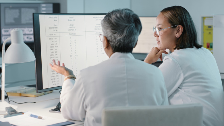 female scientists discussing data on large screen