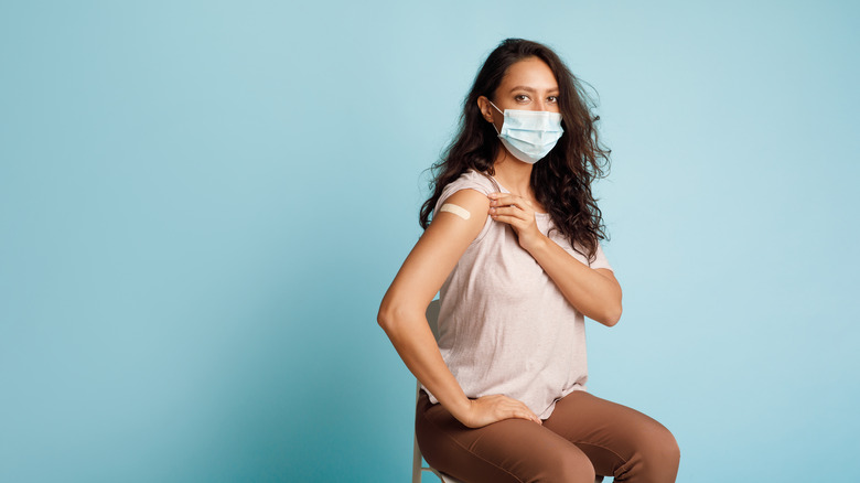 A woman shows off her COVID vaccine