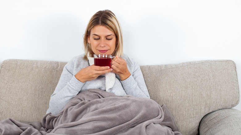 A woman drinks a cup of tea