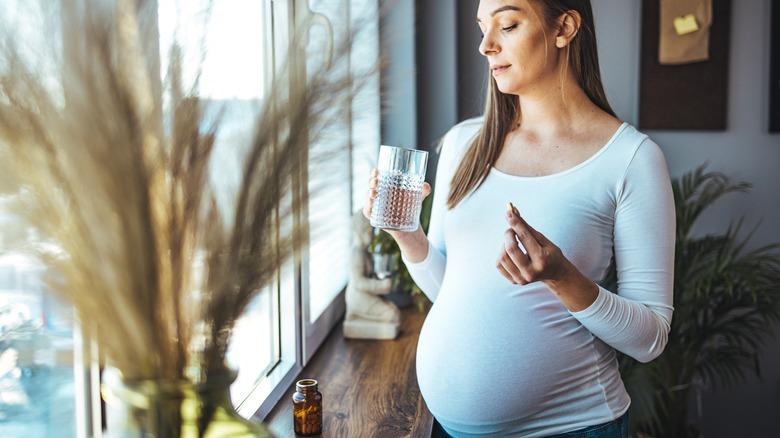 pregnant woman taking a heartburn pill