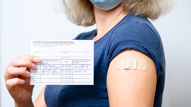woman holding vaccine record card