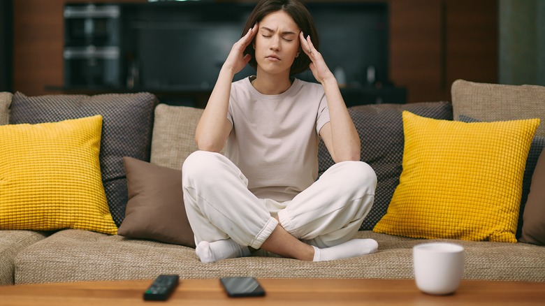 woman with headache on sofa