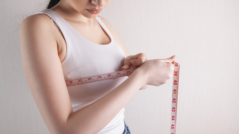 Woman measuring her bust 
