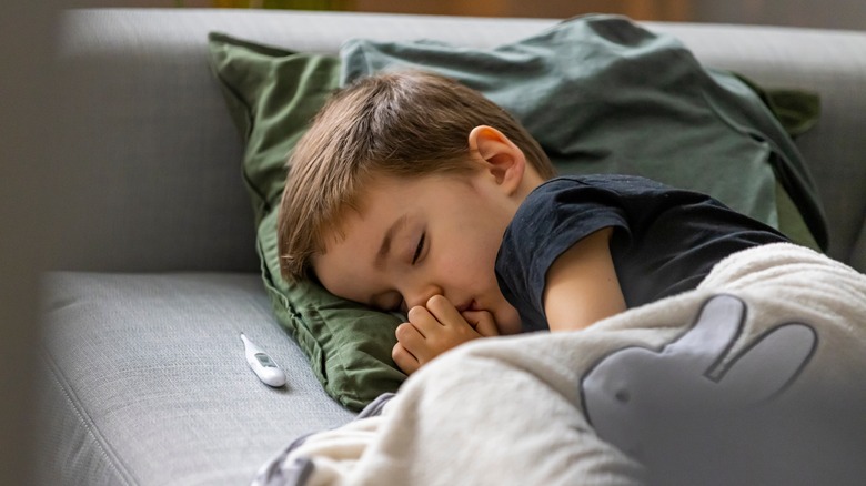 Sick child lying on couch