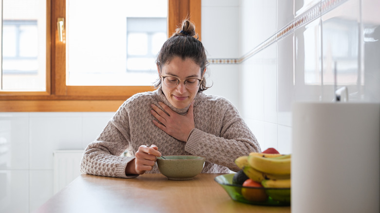 Woman wincing with sore throat