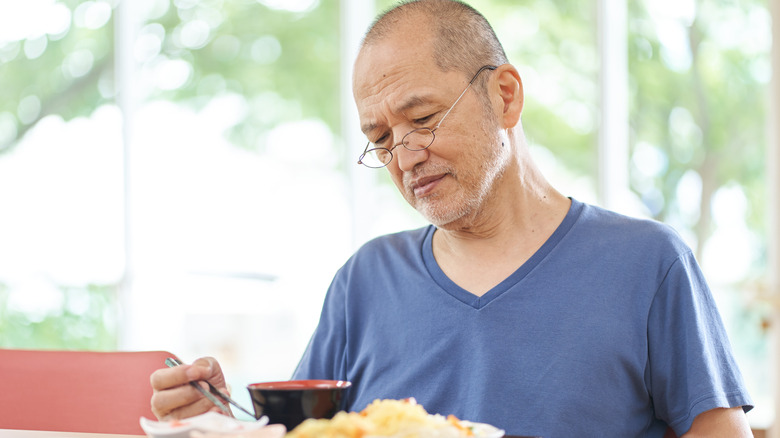 Older man uninterested in eating food