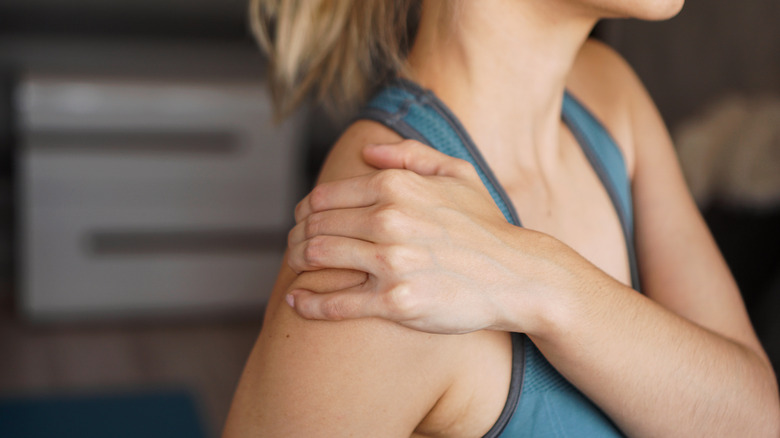 woman holding her shoulder