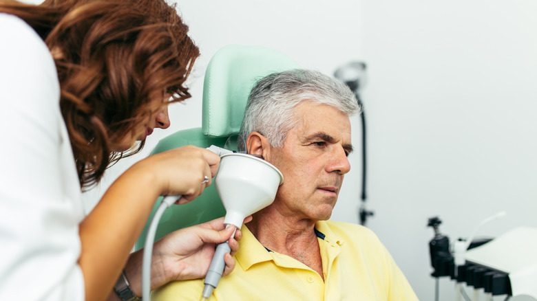 doctor cleaning out man's ear