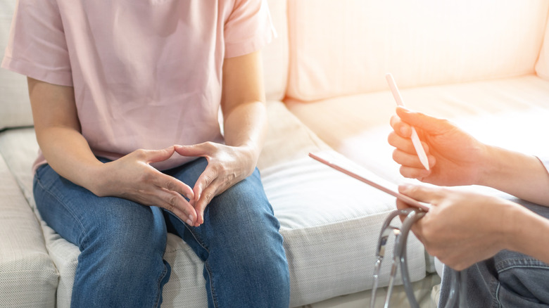 a woman nervously sits with her doctor 