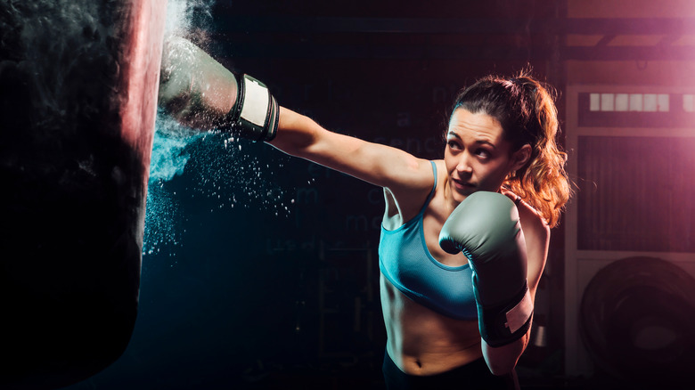 Woman hitting boxing heavy bag