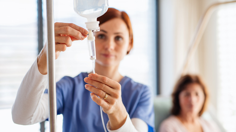 nurse preparing patient with IV drip
