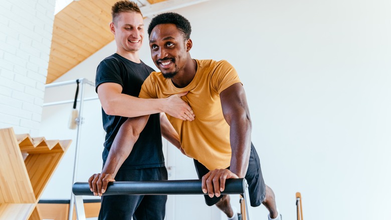 Man working with Pilates instructor